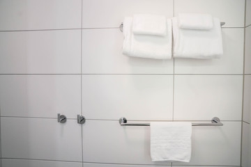 close up white soft cotton towels on bathroom rail for shower in luxury hotel