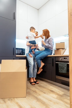 Young family unpacking boxes in new home