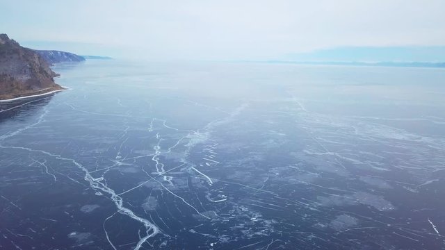 Mountains from aerial view.. Cracks in ice from aerial view. Winter in Siberia, Baikal Lake.