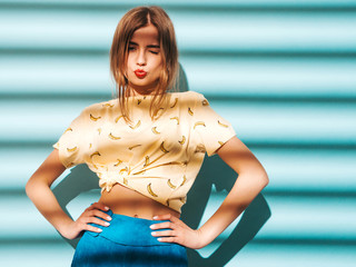 Young beautiful woman looking at camera. Trendy girl in casual summer yellow T-shirt clothes....