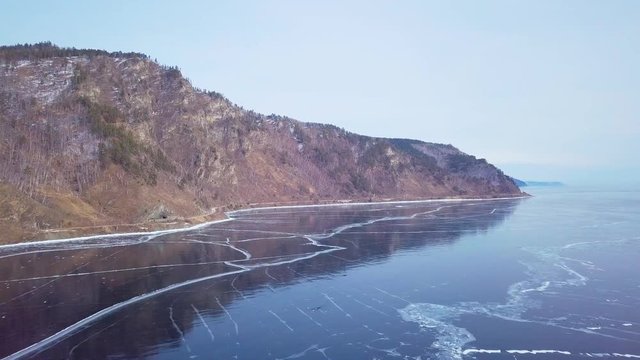 Mountains from aerial view.. Cracks in ice from aerial view. Winter in Siberia, Baikal Lake.
