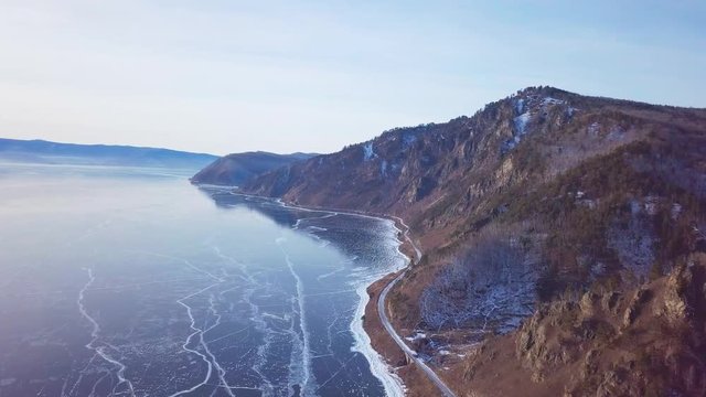 Mountains from aerial view.. Cracks in ice from aerial view. Winter in Siberia, Baikal Lake.