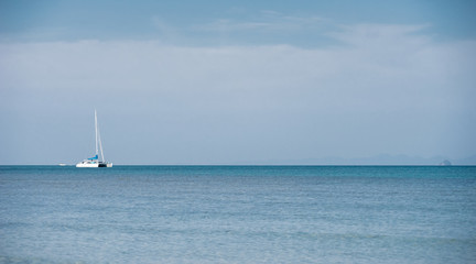 A white luxury private yacht at the tropical sea with bright sky near the Krabi Island, Thailand.