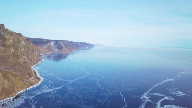 Mountains from aerial view.. Cracks in ice from aerial view. Winter in Siberia, Baikal Lake.