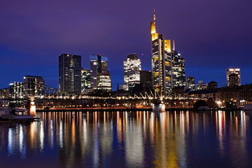 Fototapeta na wymiar Blick über den Main auf die Skyline von Frankfurt am Main in Hessen, Deutschland zur blauen Stunde