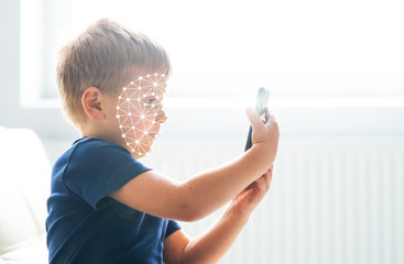 Kid using face id recognition. Boy with a smartphone gadget. Digital native children concept.