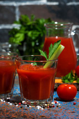 fresh tomato juice with celery in glasses, vertical