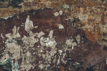 Dark brown dirty flaky shabby stucco on the wall. Abstract cracked wall texture. Old vintage stuccoing background. Dark   brown ragged wall texture. Dark brown grunge background. Brown paper texture. 