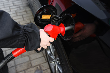 Hand refilling the car with fuel at the gas station.