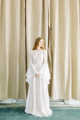 Fototapeta na wymiar Beautiful bride on a white minimalistic background. Wedding preparations in fine art.