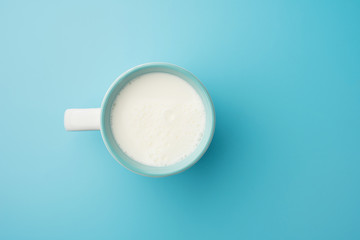Cup with milk bubble foam on top view isolated t on blue background food drink object design