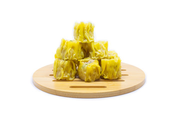 Dim Sum dumplings placed on a wooden tray and a white backdrop