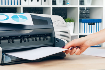 Female secretary making photocopies on xerox machine in office