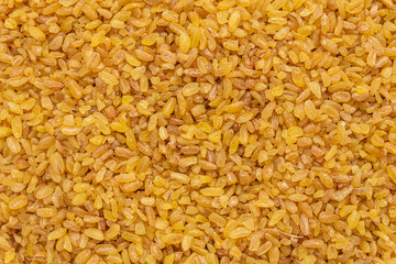 Bulgur in a white saucer on a gray concrete background