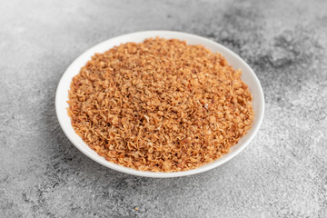 Buckwheat cereal in a white saucer on a gray concrete background