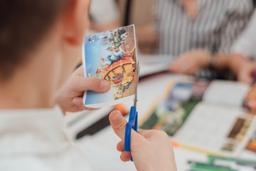 boy cuts with scissors a picture from a magazine