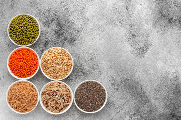 Variations of porridges and bean in white saucers on a gray concrete background