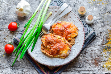Pork chop baked with vegetables and cheese with fresh tomatoes and green onions.
