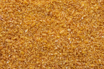 Wheat porridge in a white saucer on a gray concrete background