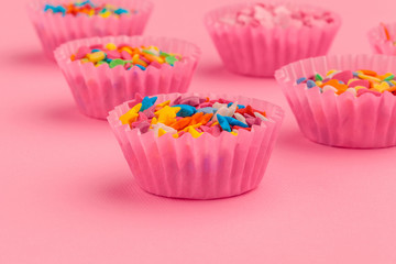 Sugar sprinkles  food background on pink cardboard