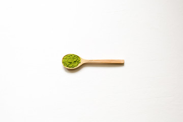 Matcha. Japanese powdered green tea in a spoon on a white background. Top view and copy space.