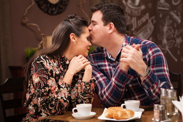 Young beautiful couple in restaurant showing affection.