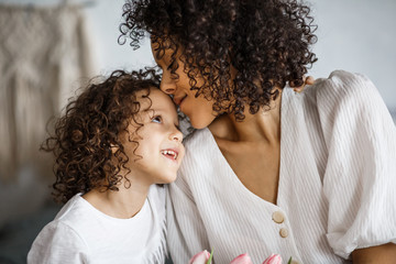 Happy mother's day, daughter gives a bouquet of tulips. African-American girl with a smile without...