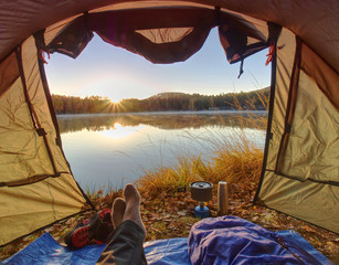 Man body in tent at lake in beautiful morning.