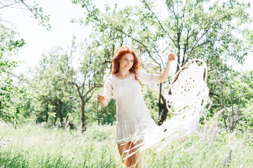 Young red hair woman holding white dream catcher