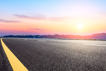 Asphalt road and beautiful mountain nature landscape at sunset