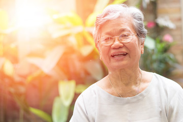 Happy senior society concept. Portrait of Asian female older ageing woman smiling with happiness in garden at home, nursing home, or wellbeing county