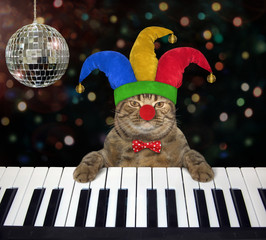 The cat musician in a jester hat and a bow tie plays the piano near the mirror ball in the night...