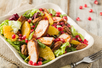 Spring salad with chicken, pomegranate, orange, pecan nuts and honey.
