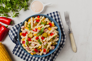 Italian fusilli pasta in a salad with ham and vegetables.