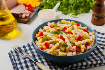 Italian fusilli pasta in a salad with ham and vegetables.