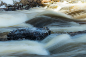 Long exposure photo. Rough river Jokelanjoki and stones in water, Kouvola, Finland.