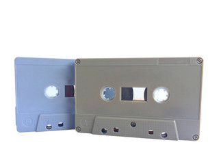 Obraz premium Old classic audio gray and brown tape cassette overlapping isolated on white background