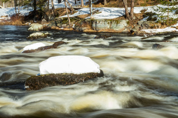 Long exposure photo. Rough river Jokelanjoki and stones in water, Kouvola, Finland.