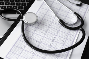 Stethoscope and cardiogram on table in clinic