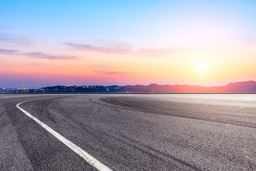 Asphalt race track ground and beautiful mountain nature landscape at sunset