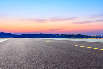 Fototapeta premium Asphalt road and beautiful mountain nature landscape at sunset