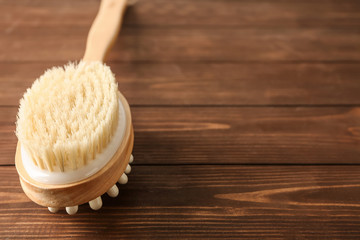 Massage brush on wooden background