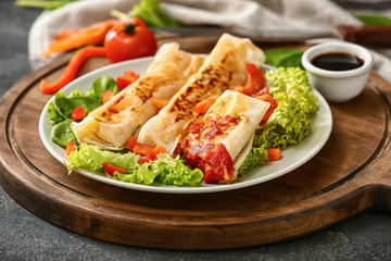 Plate with tasty fried spring rolls on table