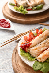 Plate with tasty fried spring rolls on table
