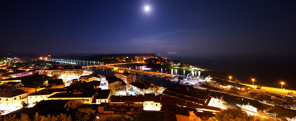Fototapeta na wymiar Moon and night view on Castiglione della Pescaia.