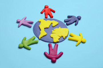 Plasticine figurines of people of different races are on planet earth. A variety of interactions, communication and globalization. Cartoon art.