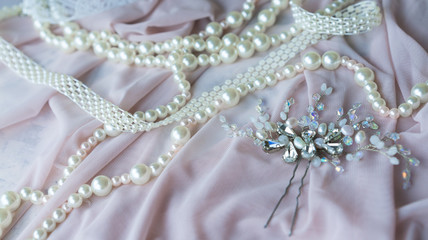Obraz premium Wedding background with pearls and hair accessories on pink background