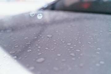 Water droplet on the car hood. Water beading after rain or car wash on white shiny paint surface. Beading created by ceramic coat or paint sealant with high surface tension. Water drop Backgroud.