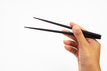 A hand holding a black wooden chopsticks isolated on white background 