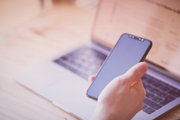 Businessman working with modern devices. Close up male hands, smart phone and laptop. Business, technology, office concept. 